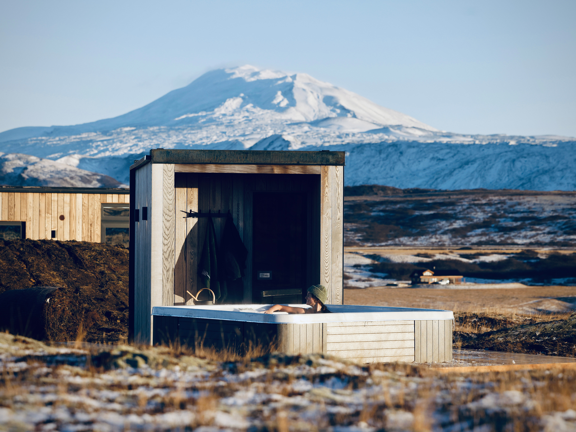 以火山景色為背景的 ÖÖD Hekla Horizon 露天熱水浴池。